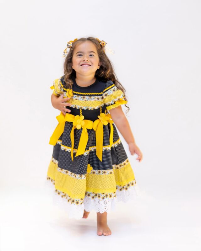 Vestido Eva em amarelo com mix de poás e girassóis, laços aplicados e acabamentos em renda branca — cheio de alegria e delicadeza para brilhar no arraial. 🌻 #FestaJunina2025 #PipeEtMila #LookJuninoInfantil